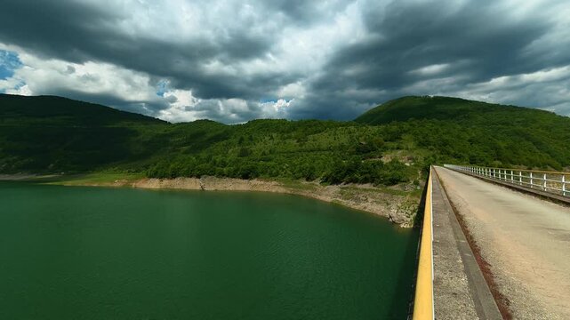 Dark clouds loom above the green hills. Zavoj Lake, Serbia