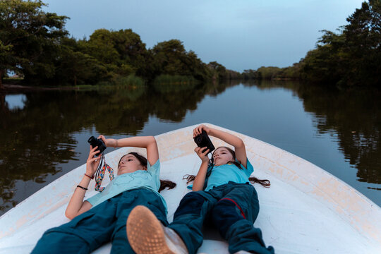 Two Girls taking photos with camera on boat. Sri Lanka
