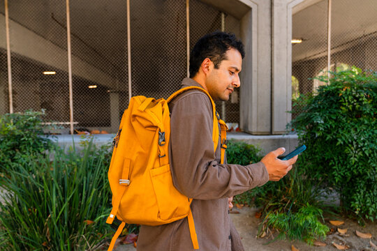 casual man using mobile phone in city