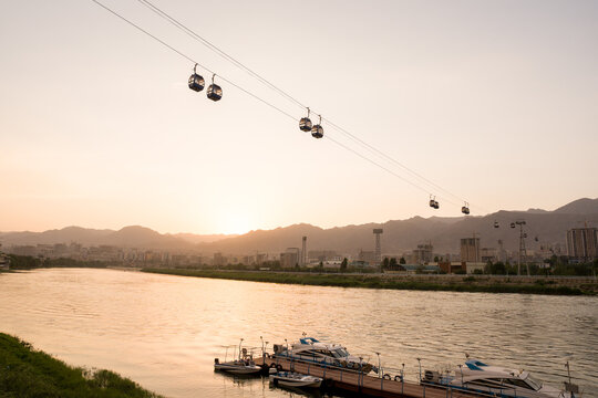 Cable Cars Travel Over Syr Darya River At Sunset