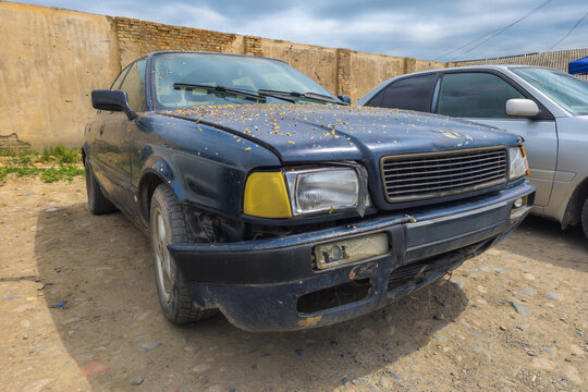 Damaged Dark Blue Sedan Parked on Dirt Lot