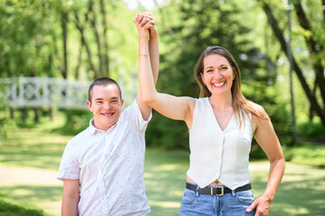 Obraz premium boy with Down syndrome in a park with his mother