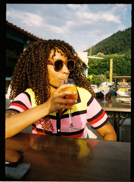 Person enjoying refreshing cocktail drink at outdoor cafe
