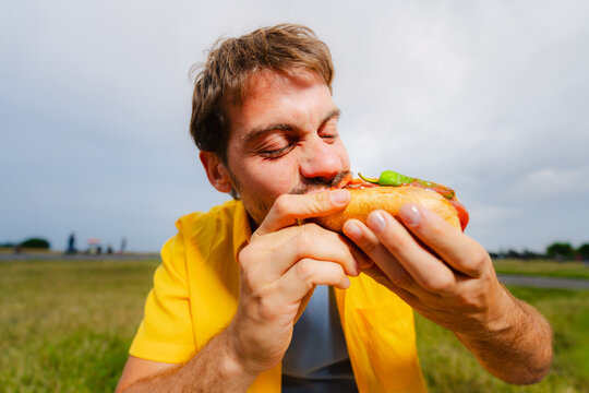 Man Biting Into Loaded Hot Dog