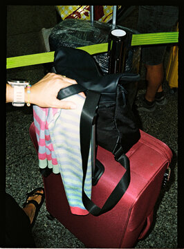 Travelers waiting in a queue with luggage at an airport