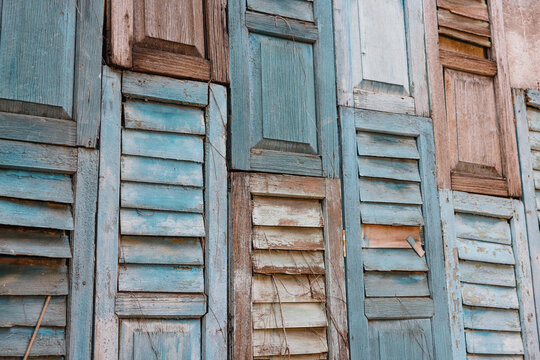 Weathered blue wooden shutters on old building facade
