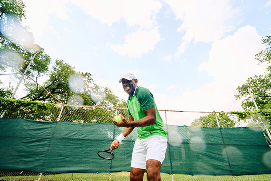 Man laughing playing tennis