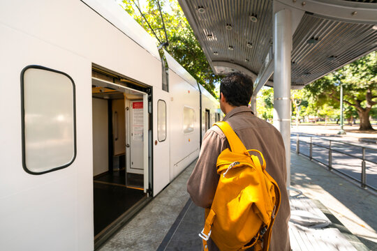 casual man public transportation commute getting onto train