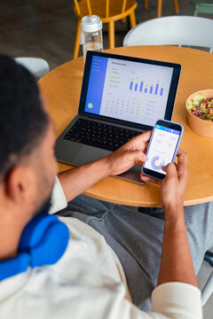 Businessman Checking Analytics on Laptop and Phone