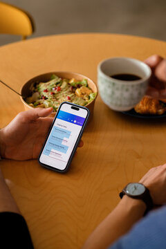 Person Checking a To Do List On Phone Over Breakfast