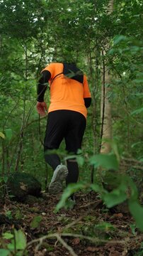 Man trail running through a forest during an outdoor workout. He challenges himself to improve fitness and endurance while pursuing personal goals and a healthy active lifestyle.
