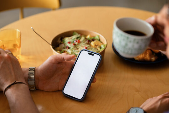 Hands Holding Smartphone at Casual Breakfast Table