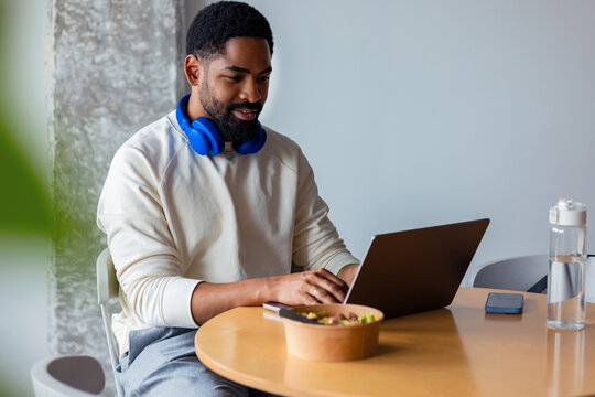 Man Working Remotely on Laptop With Headphones