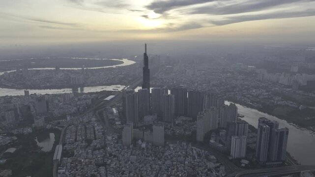 Aerial drone view of Landmark 81 in Thanh My Tay Ward, Ho Chi Minh City, Vietnam, with bright sunlight illuminating the iconic skyscraper and surrounding modern urban landscape.