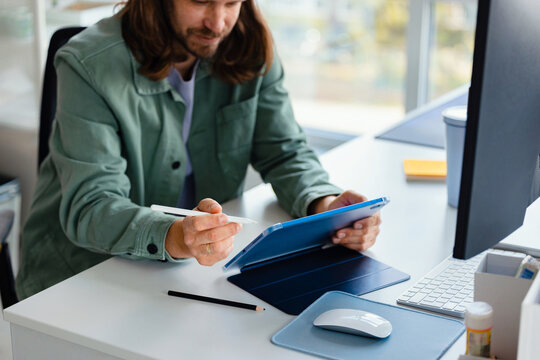 Designer Working on a Tablet with Stylus at Office 