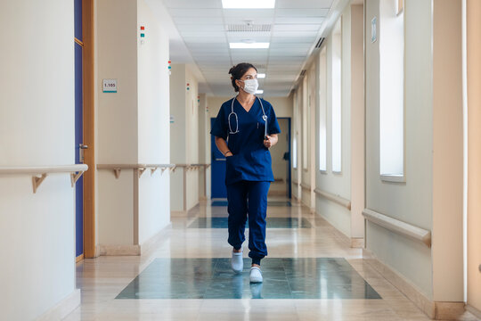 Healthcare professional walking corridor, working at hospital