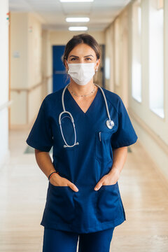 Female doctor wearing scrubs and protective face mask