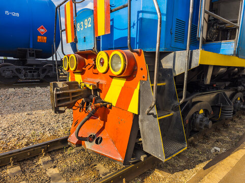 Close-up of Blue and Orange Locomotive Engine on Tracks