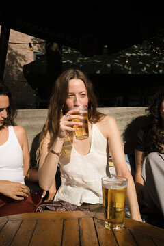 Friends enjoy drinks at an outdoor bar on a sunny day