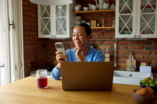 Woman works from her apartment, checking the phone