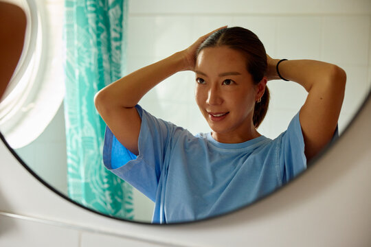 Woman prepares herself in the bathroom.