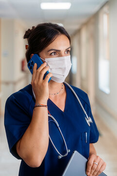 Medical professional talking on phone in hospital hallway