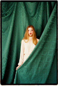 Woman behind green curtain