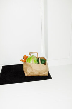 Food grocery store delivery in a brown paper bag in the hallway