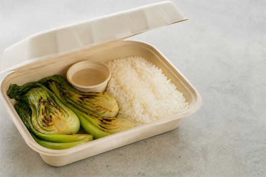Grilled bok choy and rice in sustainable takeaway packaging
