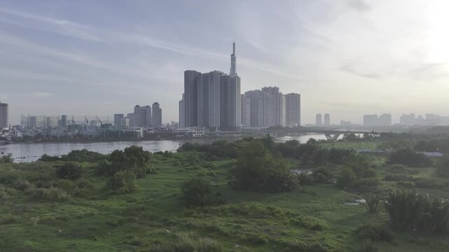 Aerial drone view of Landmark 81 in Thanh My Tay Ward, Ho Chi Minh City, Vietnam, with bright sunlight illuminating the iconic skyscraper and surrounding modern urban landscape.