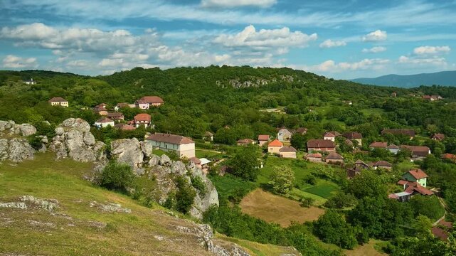 Village nestles among green hills and stone formations. Vrmdza Fortress. Serbia