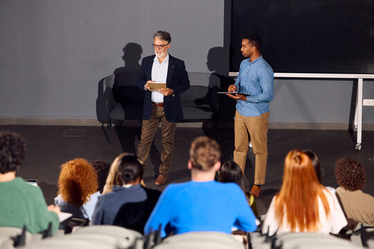 Two Speakers Present to an Audience in a Lecture Hall