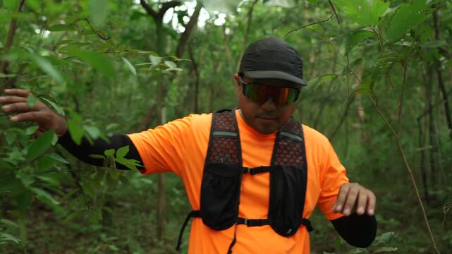 Man trail running through a forest during an outdoor workout. He challenges himself to improve fitness and endurance while pursuing personal goals and a healthy active lifestyle.
