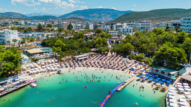 Aerial drone view of the famous Bora Bora beach bar, sandy cove, and turquoise water in Ksamil, Albania