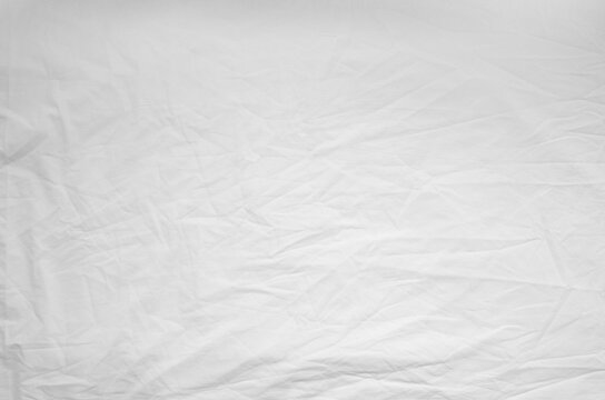 Top view of wrinkles on an unmade bed sheet after waking up in the morning.