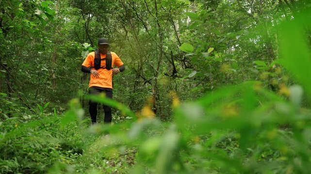 Man trail running through a forest during an outdoor workout. He challenges himself to improve fitness and endurance while pursuing personal goals and a healthy active lifestyle.

