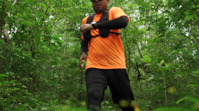 Man trail running through a forest during an outdoor workout. He challenges himself to improve fitness and endurance while pursuing personal goals and a healthy active lifestyle.
