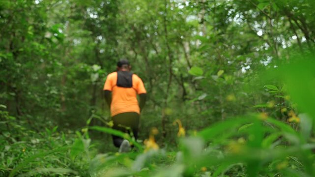 Man trail running through a forest during an outdoor workout. He challenges himself to improve fitness and endurance while pursuing personal goals and a healthy active lifestyle.
