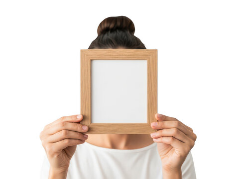 Woman holding a blank picture frame in front of her face