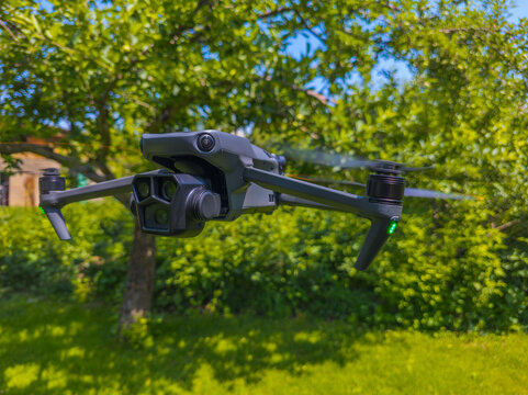 Gray Drone in Flight Over Green Foliage