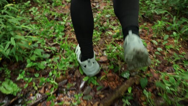 Close-up of a man's running shoes splashing through water on a forest trail. Extreme outdoor sport highlights endurance, adventure, fitness goals and the challenge of an active lifestyle.
