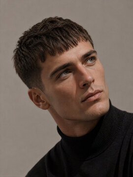 Man with short hair wearing a black turtleneck sweater