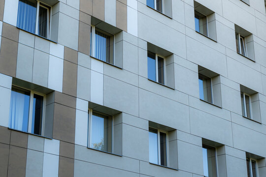 Geometric pattern of windows and rectangular facade panels on a modern contemporary building