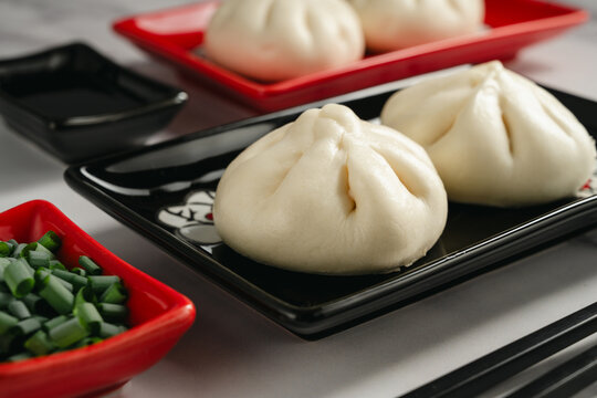 Chinese steamed bao buns served with chopped green onion
