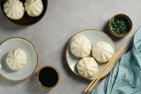 Asian steamed bao buns with dipping sauce and chopped scallions, copy space