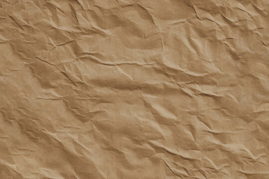 Crushed brown paper texture background with realistic wrinkle detail and natural kraft surface pattern