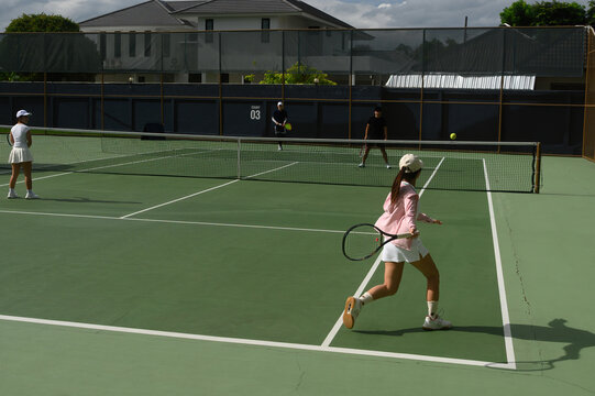 Mixed Doubles Tennis Competition on Outdoor Green Hard Court with Four Players in Action