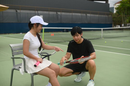 Tennis Coach Teaching Young Girl Beginner How to Hold Racket on Outdoor Court