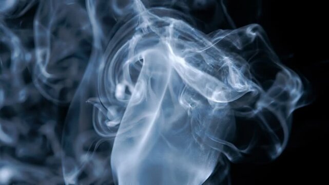 Silky fluid smoke texture isolated in an abyss of pure darkness, smoke background ideal for mystery branding, motion graphics design projects