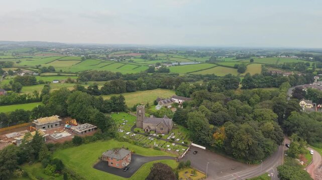High aerial view over Castlecaulfield and the drumlin farmland of County Tyrone with St Michael's Church of Ireland below, Northern Ireland